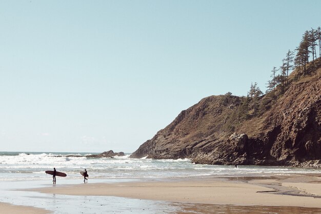 Surfers in the Distance on rocky beach