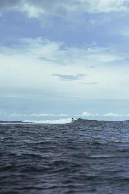 バリでのサーフィン海のサーファーが波に乗る