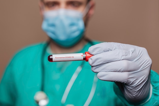 Free photo surgeon holding a covid-19 test tube