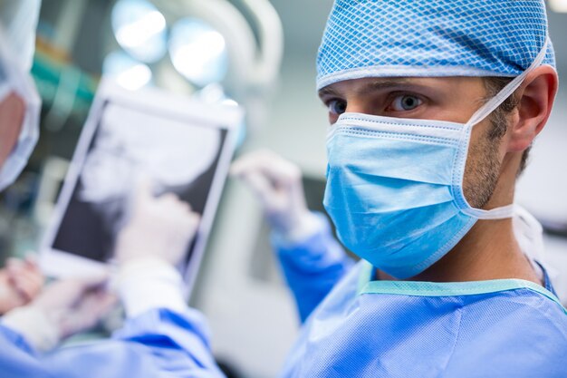 Surgeons discussing on patient x-ray in operation room