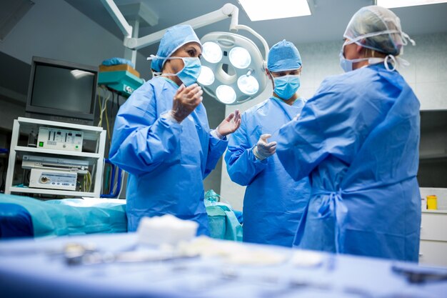 Хирурги, взаимодействующих друг с другом в комнате операции