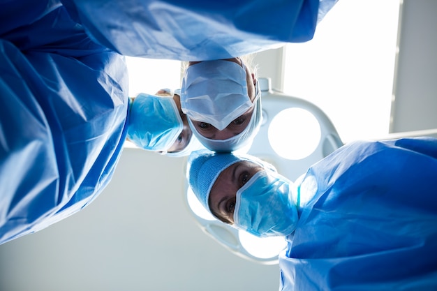 Surgeons looking at camera in operation room