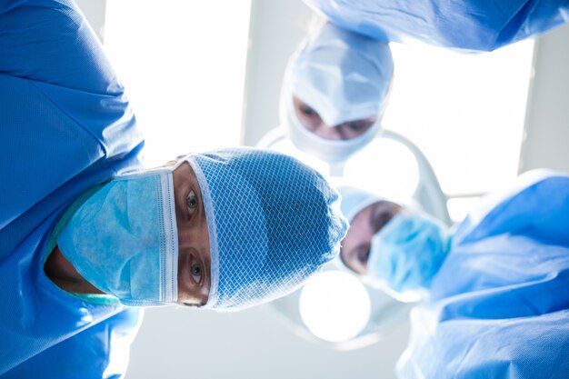 Surgeons looking at camera in operation room