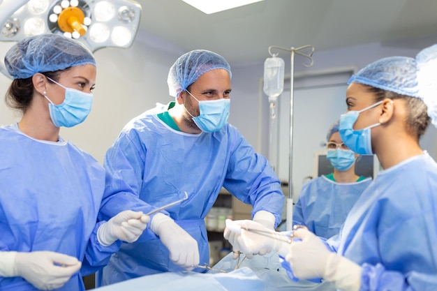 Surgeons men and women in one team during an operation over the operating table doctors in modern equipment perform an oncological operation