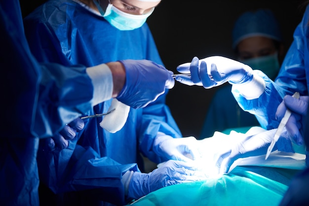 Free photo surgeons passing scissors to each other