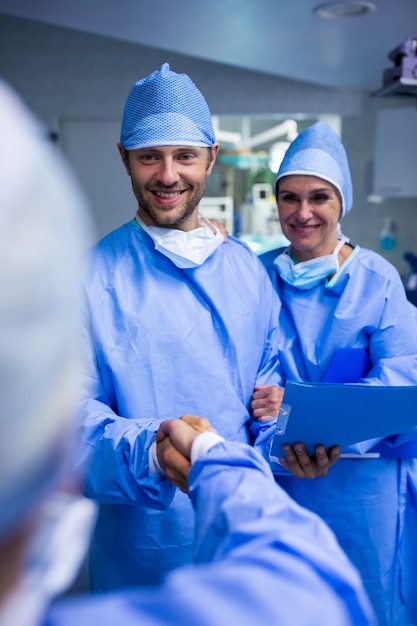 Surgeons shaking hand in operation room