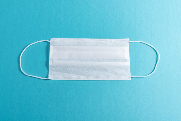 Surgical mask over minimalist blue background