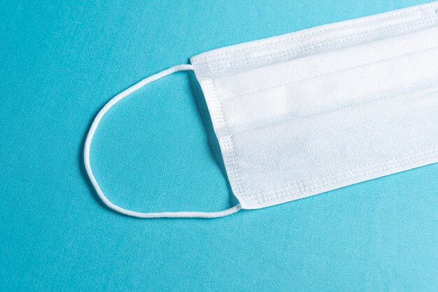 Surgical mask over minimalist blue background