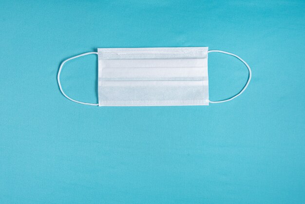 Surgical mask over minimalist blue background