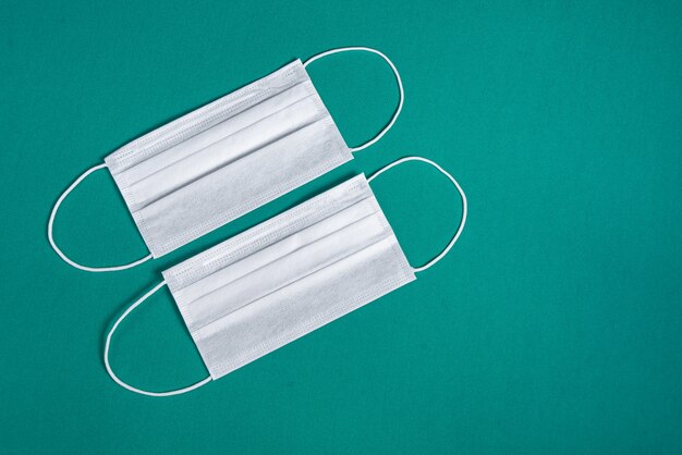 Surgical mask over minimalist green background