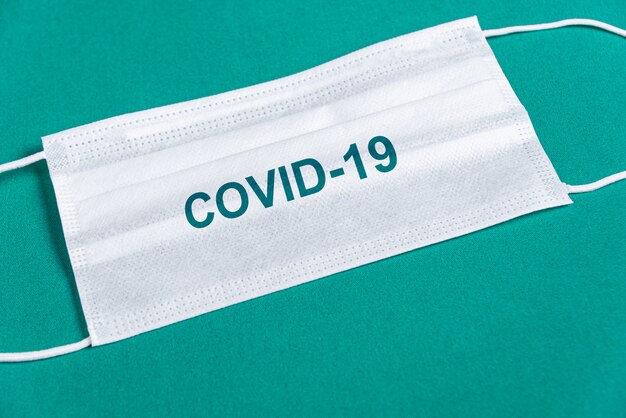 Surgical mask over minimalist green background