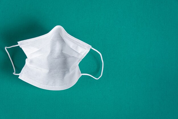 Surgical mask over minimalist green background