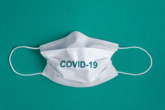 Surgical mask over minimalist green background