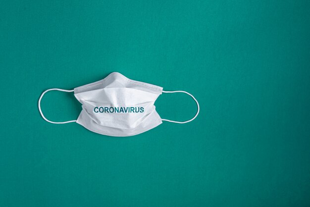 Surgical mask over minimalist green background