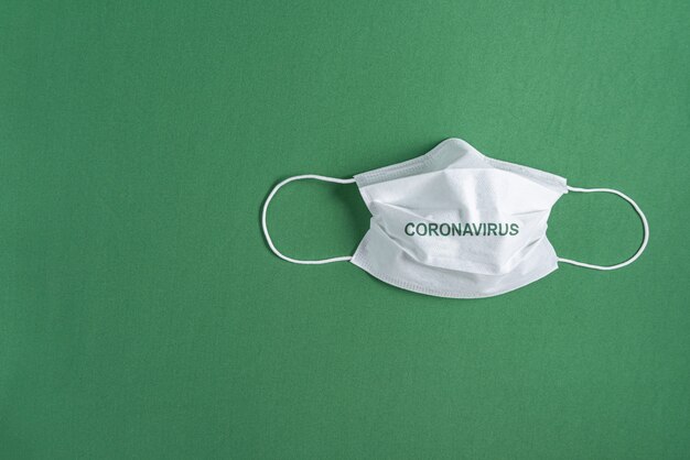 Surgical mask over minimalist green background