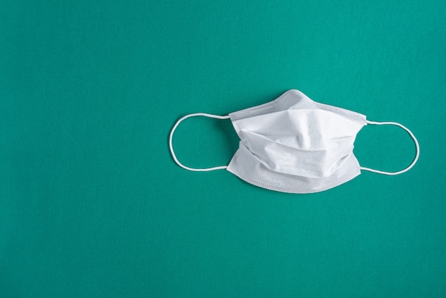 Surgical mask over minimalist green background