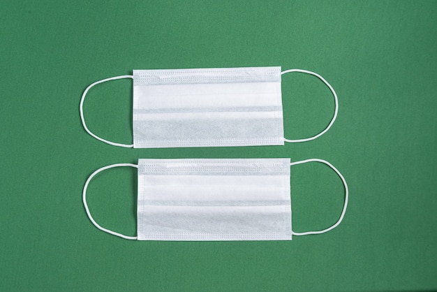 Surgical mask over minimalist green background