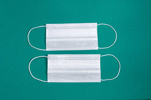 Surgical mask over minimalist green background