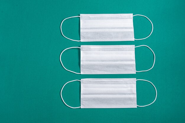 Surgical mask over minimalist green background