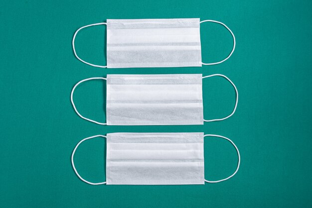 Surgical mask over minimalist green background