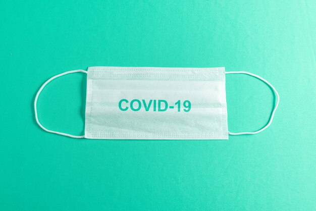 Surgical mask over minimalist green background