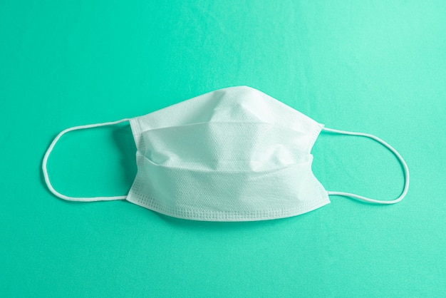 Surgical mask over minimalist green background