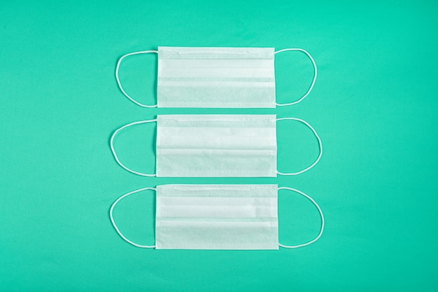 Surgical mask over minimalist green background