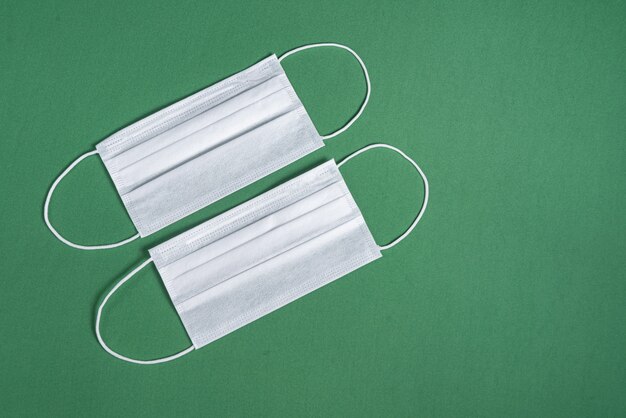 Surgical mask over minimalist green background