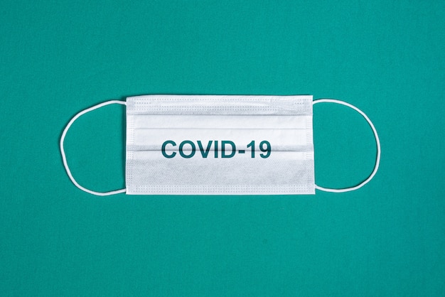 Surgical mask over minimalist green background