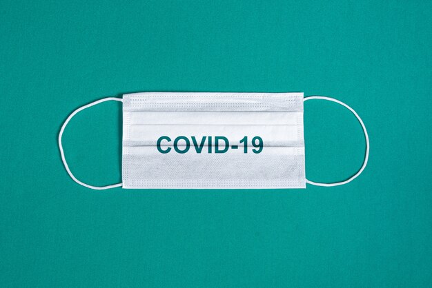 Surgical mask over minimalist green background