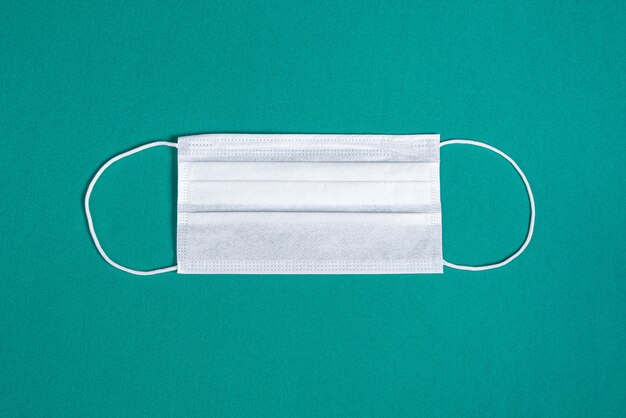 Surgical mask over minimalist green background