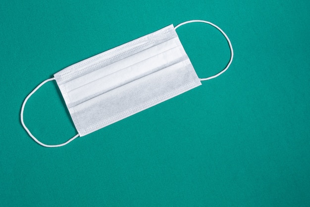 Surgical mask over minimalist green background