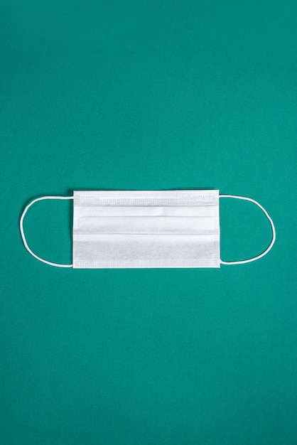 Maschera chirurgica su sfondo verde minimalista