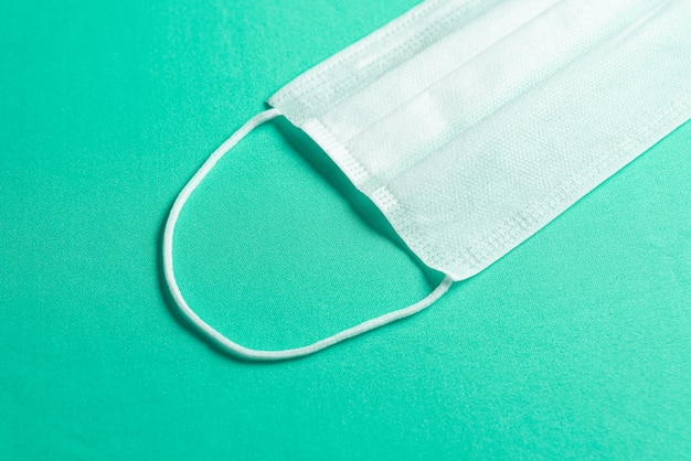 Surgical mask over minimalist green background