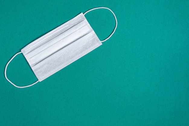 Surgical mask over minimalist green background