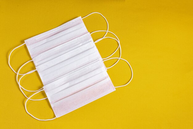 Surgical mask over minimalist orange background