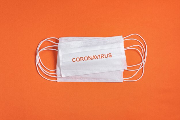 Surgical mask over minimalist orange background