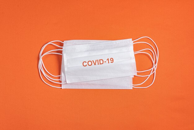 Surgical mask over minimalist orange background