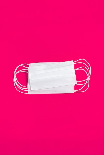 Surgical mask over minimalist orange background