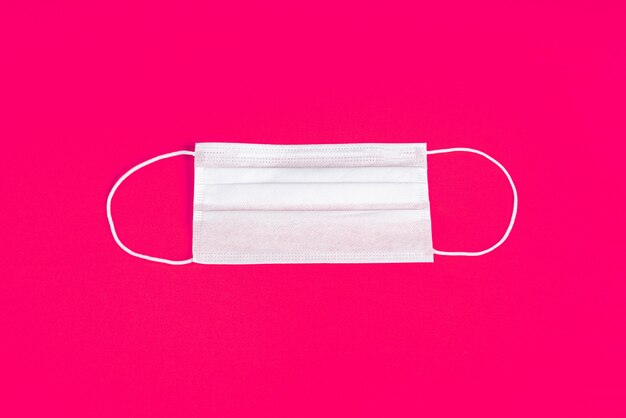 Surgical mask over minimalist orange background