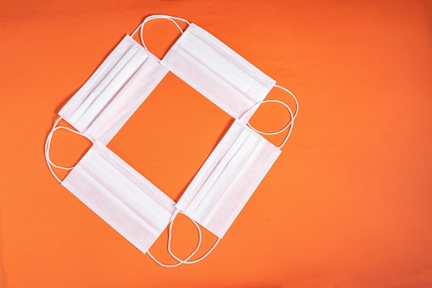 Free photo surgical mask over minimalist orange background