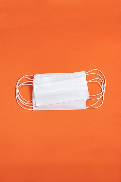 Free photo surgical mask over minimalist orange background