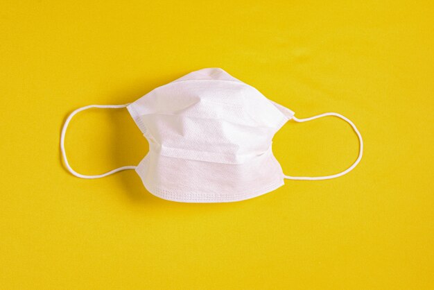 Surgical mask over minimalist orange background