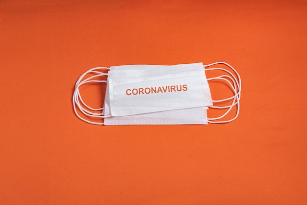 Free photo surgical mask over minimalist orange background