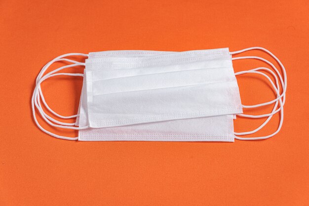 Free photo surgical mask over minimalist orange background