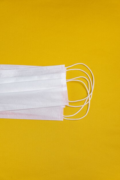 Surgical mask over minimalist orange background