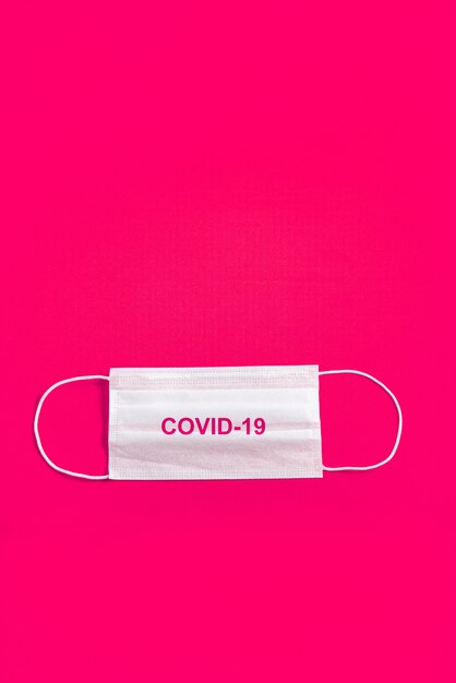 Surgical mask over minimalist orange background