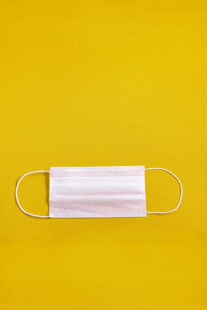 Surgical mask over minimalist orange background