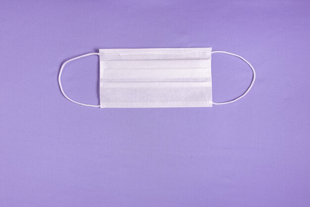 Хирургическая маска на минималистском фиолетовом фоне