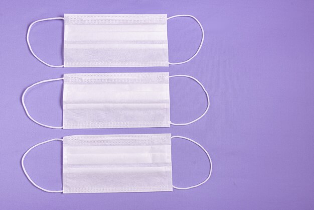 Surgical mask over minimalist purple background